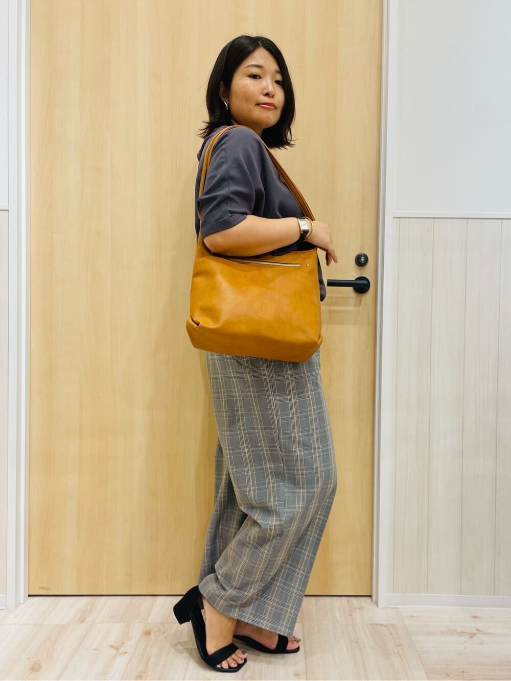 グレー系のシャツ/ブラウス、グレー系のその他パンツ、ブラック系のサンダルを着用したレディースの秋コーディネートの2枚目の写真