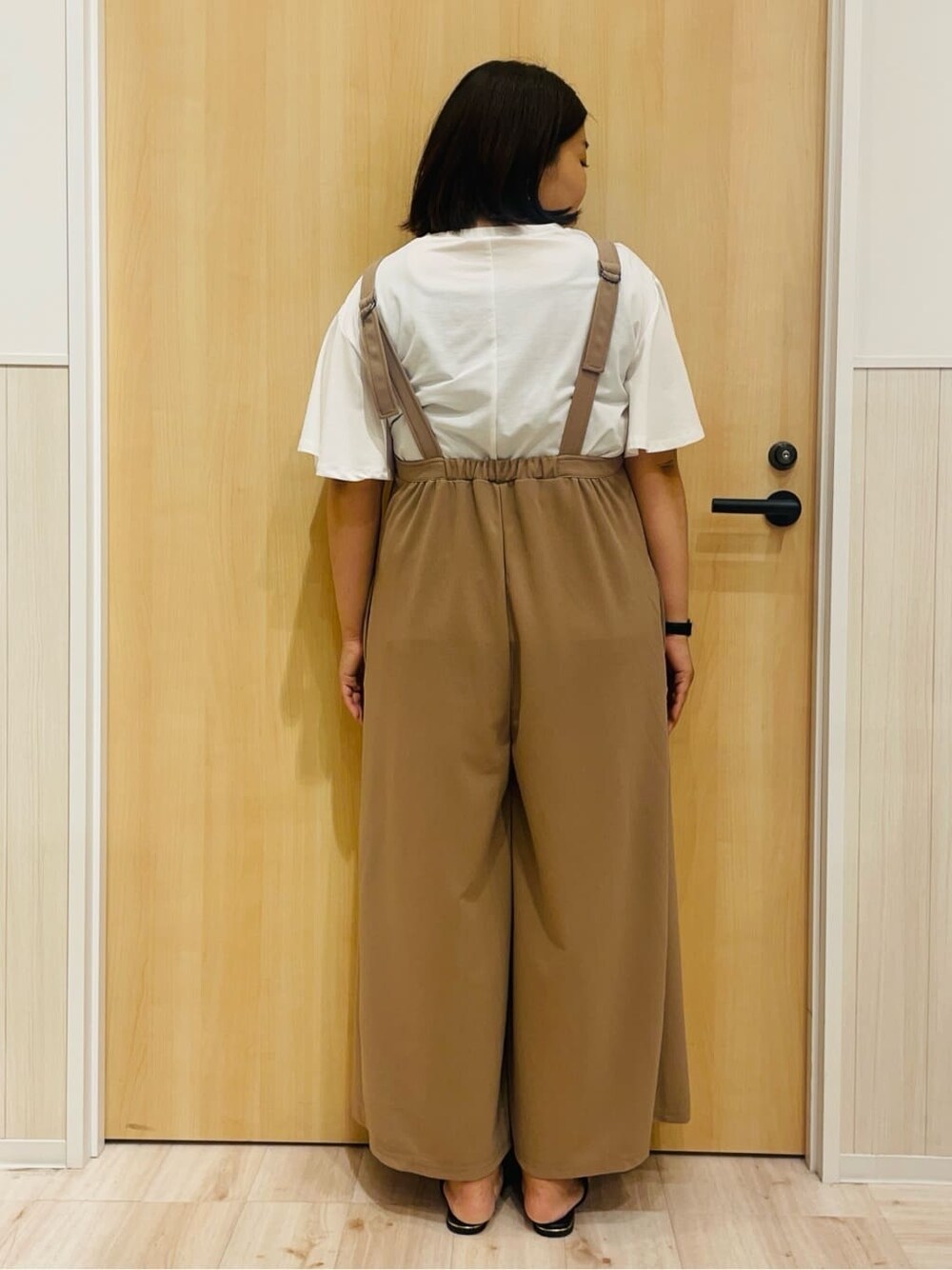 ホワイト系のTシャツ/カットソー、ブラウン系のサロペット/オーバーオール、ブラック系のサンダルを着用したレディースの夏コーディネートの3枚目の写真