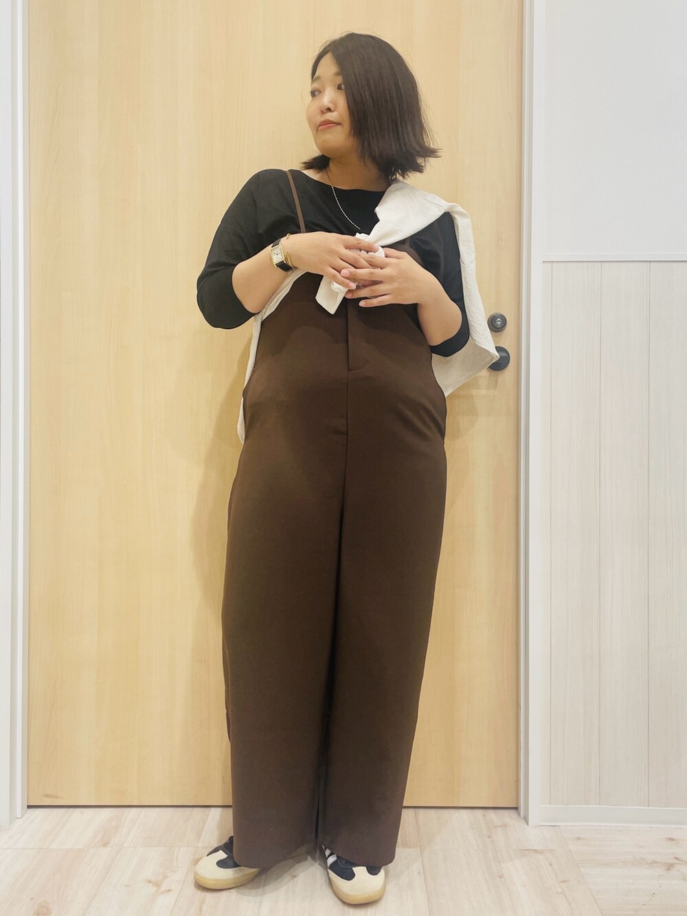 ブラウン系のサロペット/オーバーオール、ブラック系のTシャツ/カットソー、ベージュ系のシャツ/ブラウスを着用したレディースの秋コーディネートの4枚目の写真