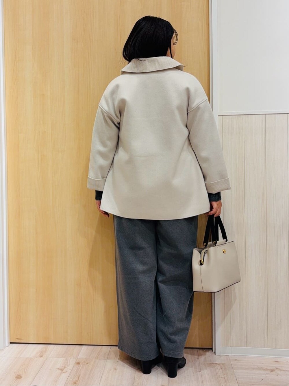 ホワイト系のテーラードジャケット、グレー系のニット/セーター、グレー系のその他パンツを着用したレディースの冬コーディネートの3枚目の写真