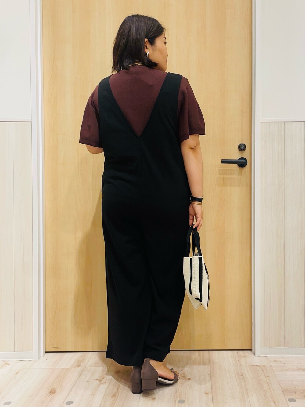 ブラック系のサロペット/オーバーオール、ブラウン系のニット/セーター、ベージュ系のサンダルを着用したレディースの夏コーディネートの3枚目の写真