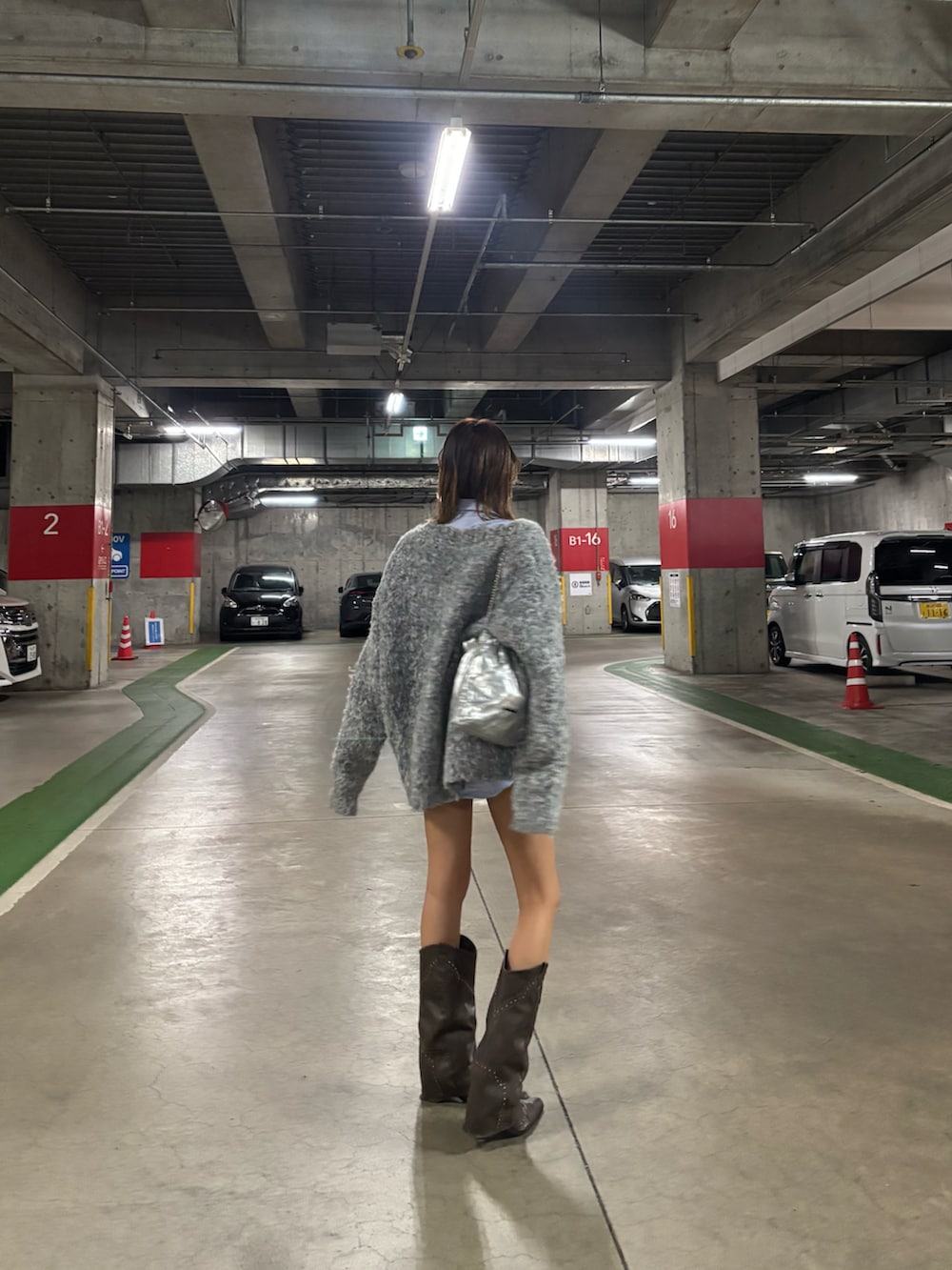 グレー系のカーディガン/ボレロ、ブラウン系のブーツを着用したレディースの秋コーディネートの2枚目の写真