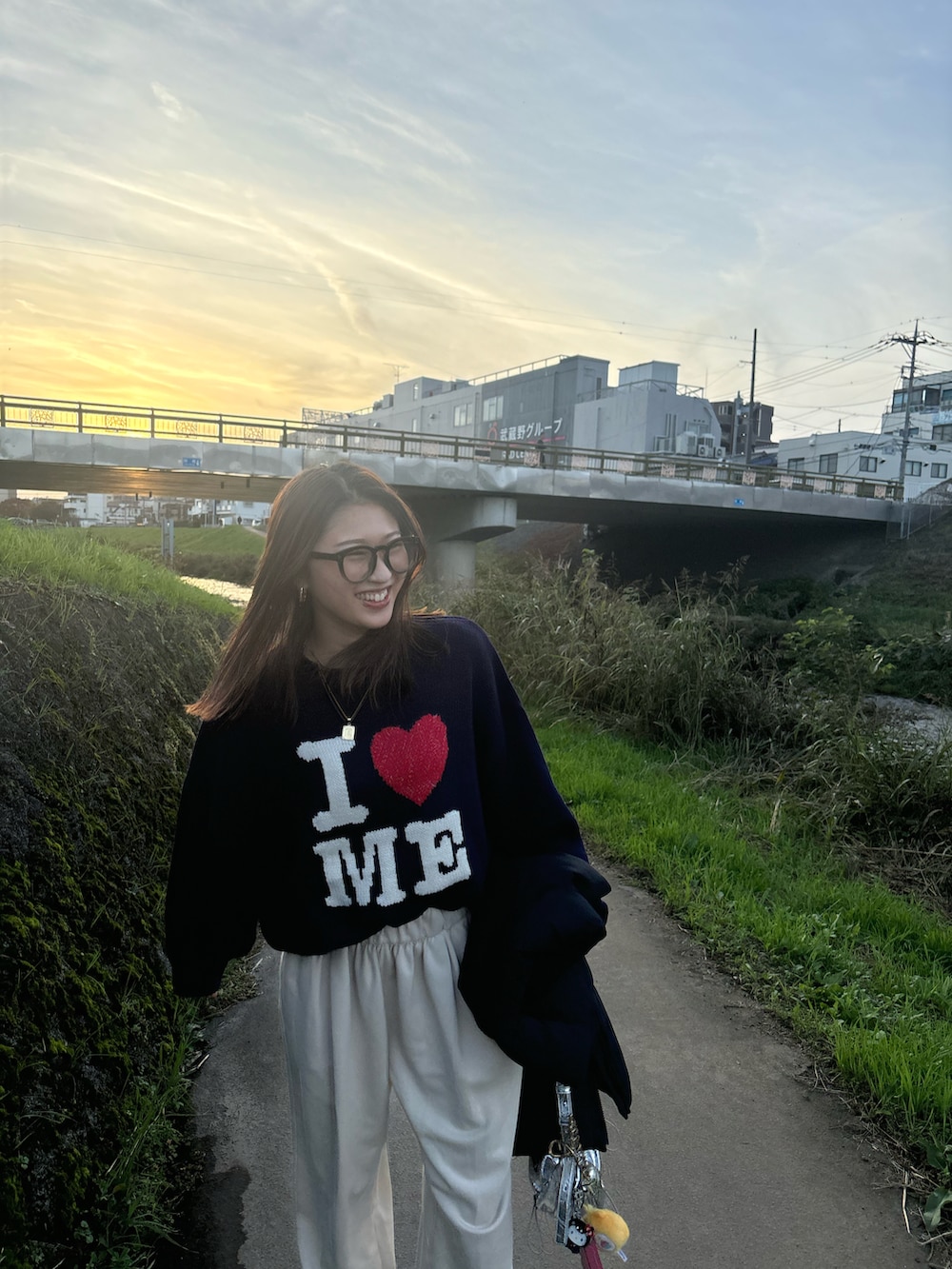 ブルー系のニット/セーター、ブラウン系のブーツ、ブラック系のダウンベストを着用したレディースの秋コーディネートの5枚目の写真