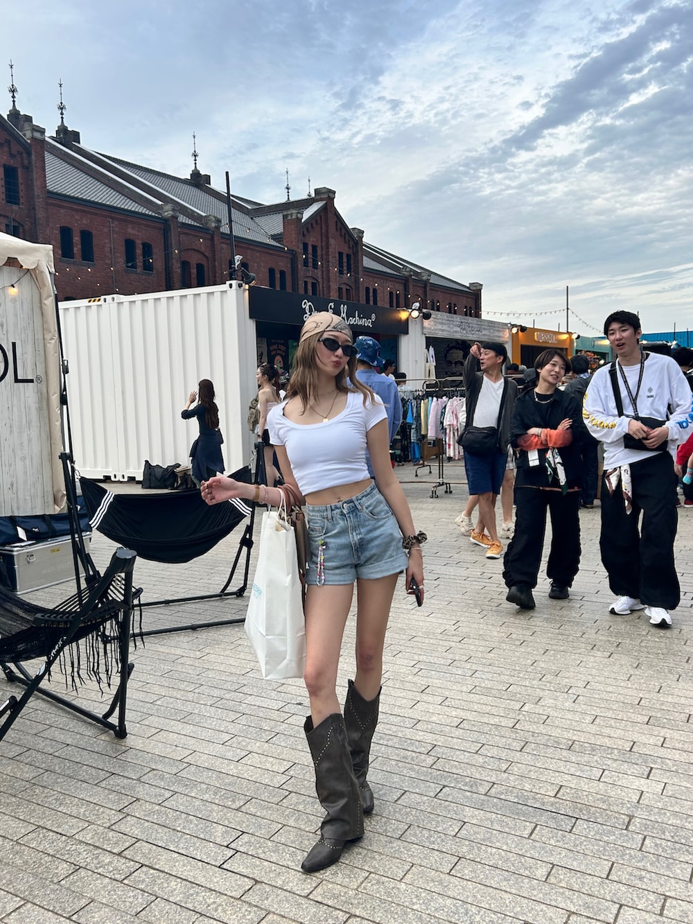 ホワイト系のTシャツ/カットソー、ブルー系のデニムパンツ、ブラウン系のブーツを着用したレディースの夏コーディネートの2枚目の写真