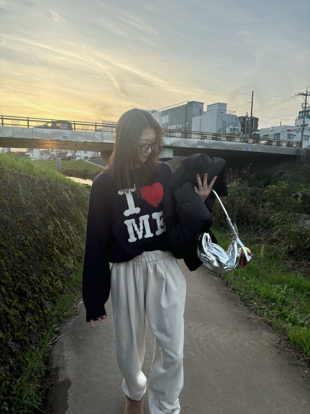 ブルー系のニット/セーター、ブラウン系のブーツ、ブラック系のダウンベストを着用したレディースの秋コーディネートの3枚目の写真