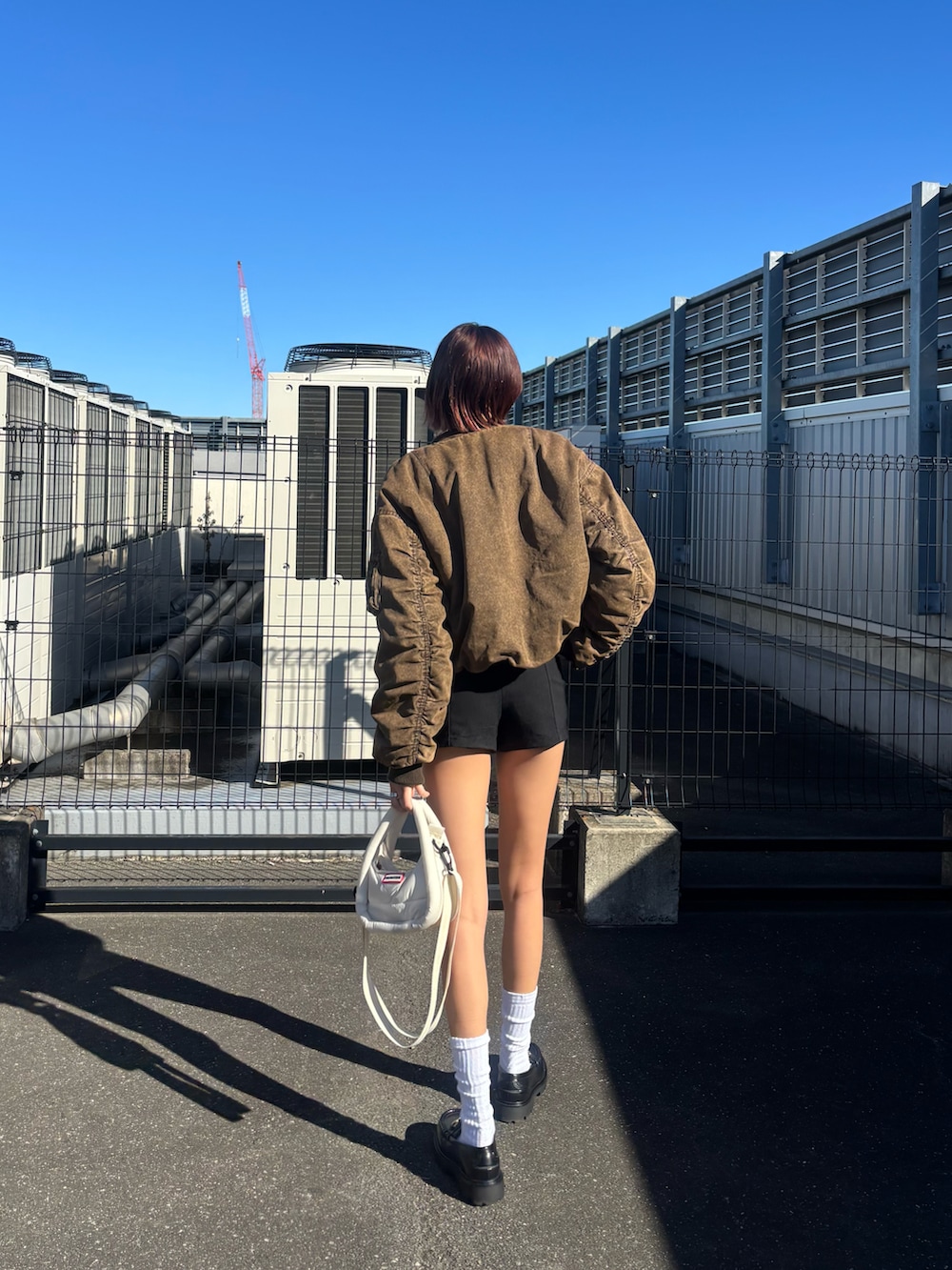 ブラック系のローファー、ブラウン系のMA-1、ブラック系のパンツを着用したレディースの冬コーディネートの3枚目の写真