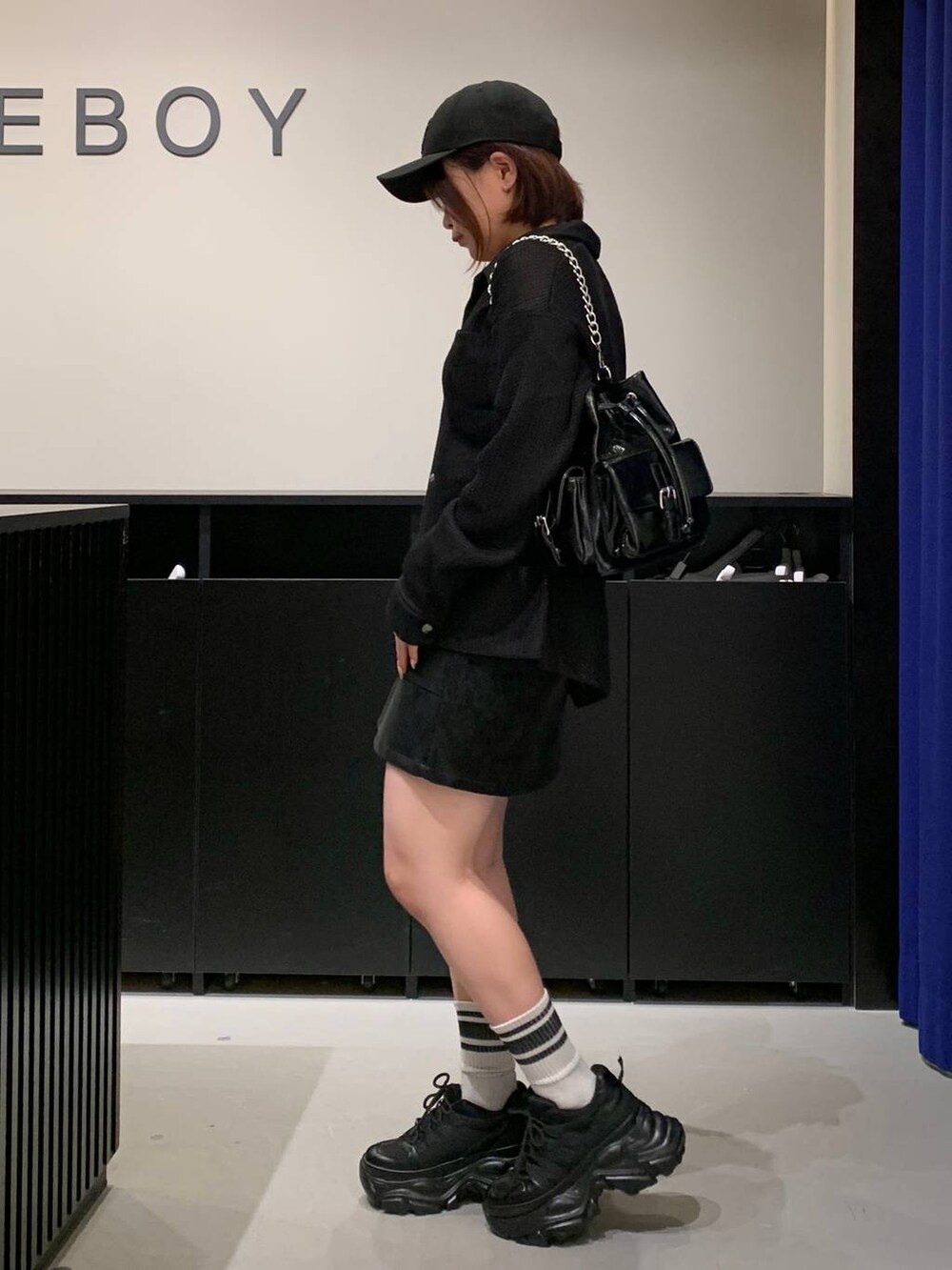 ブラック系のスニーカー、ブラック系のシャツ/ブラウス、ブラック系のショルダーバッグを着用したレディースの秋コーディネートの6枚目の写真