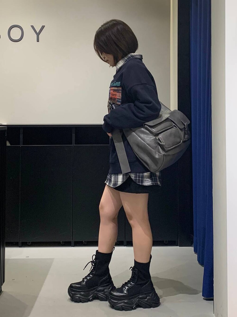 ブラック系のブーツ、グレー系のショルダーバッグ、ブラック系のスカートを着用したレディースの秋コーディネートの6枚目の写真