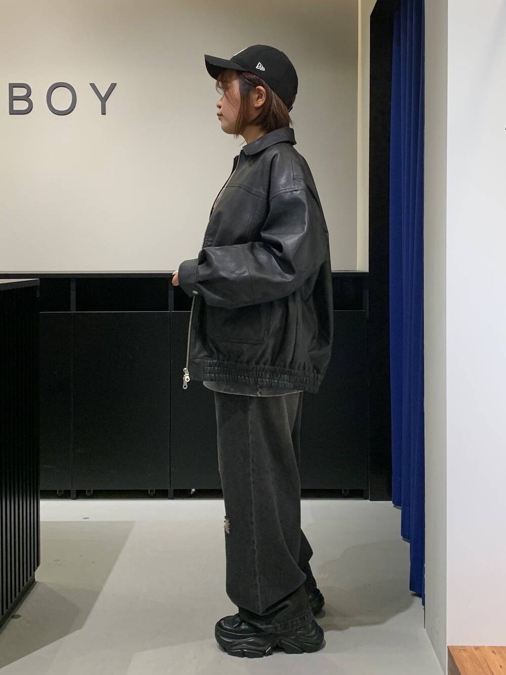 ブラック系のスニーカー、ブラック系のデニムパンツ、ブラック系のブルゾンを着用したレディースの秋コーディネートの5枚目の写真