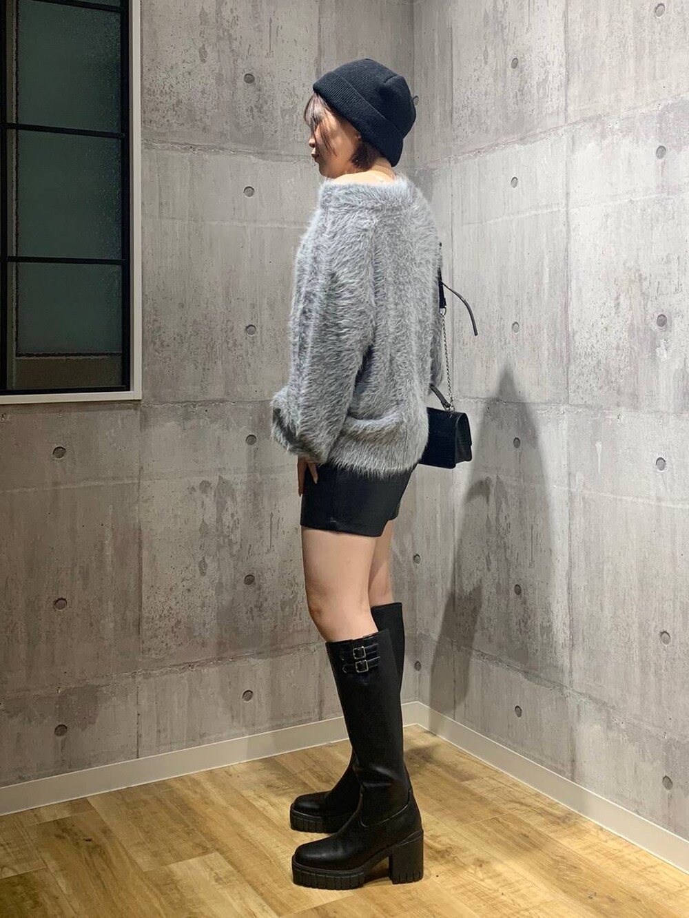 ブラック系のブーツ、ブラック系のハンドバッグ、グレー系のニット/セーターを着用したレディースの秋コーディネートの6枚目の写真