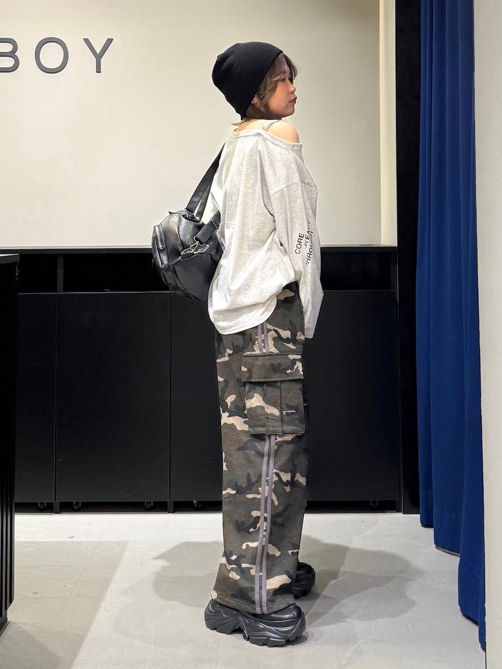 ブラック系のスニーカー、ホワイト系のキャミソール、ブラック系のショルダーバッグを着用したレディースの冬コーディネートの4枚目の写真