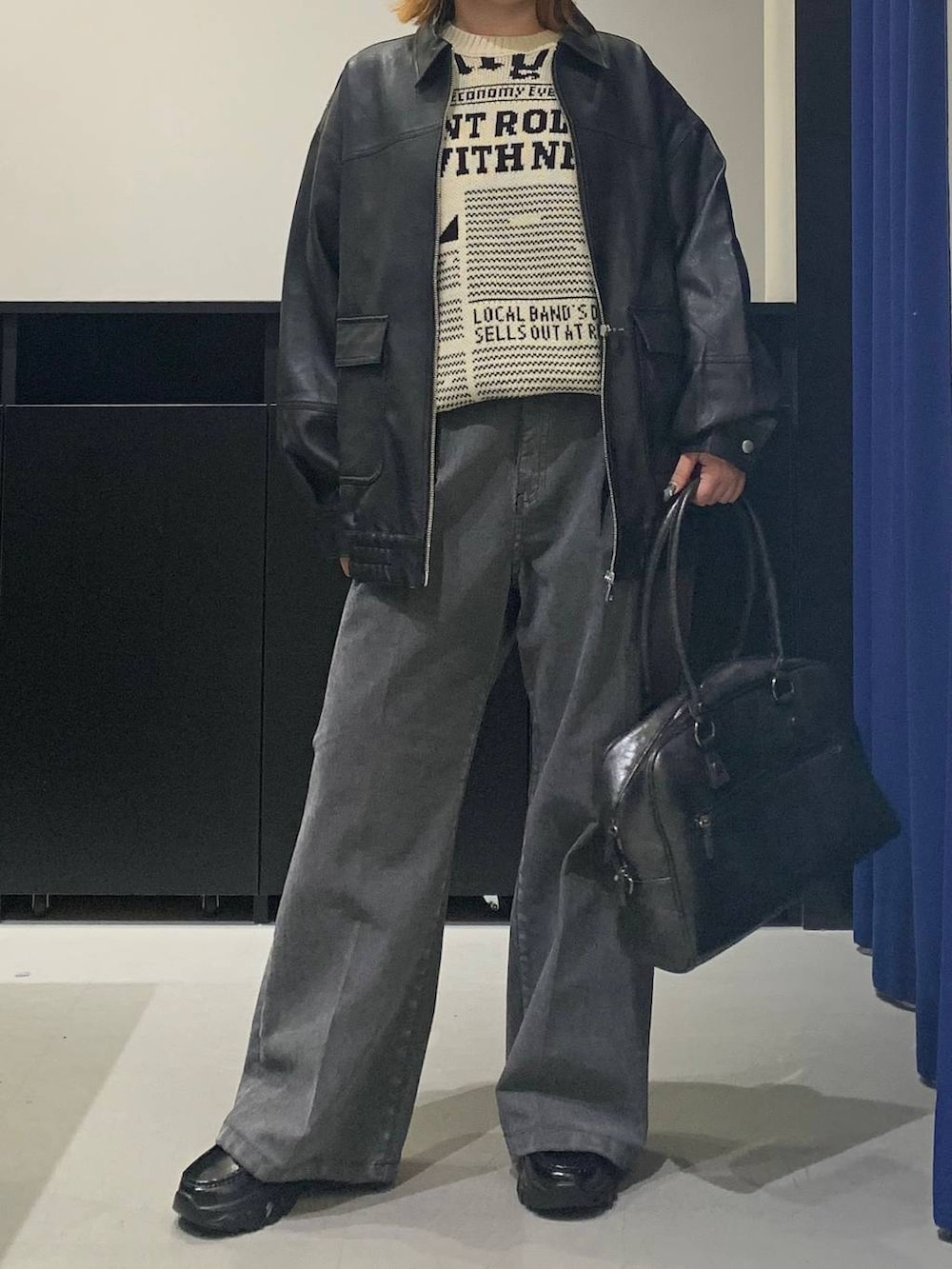 ブラック系のボストンバッグ、ブラック系のブルゾン、ブラック系のローファーを着用したレディースの冬コーディネートの2枚目の写真