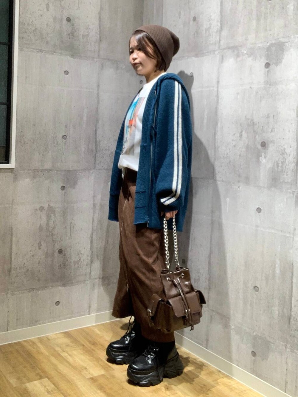 ブラック系のブーツ、ブラウン系のショルダーバッグ、ホワイト系のTシャツ/カットソーを着用したレディースの秋コーディネートの7枚目の写真