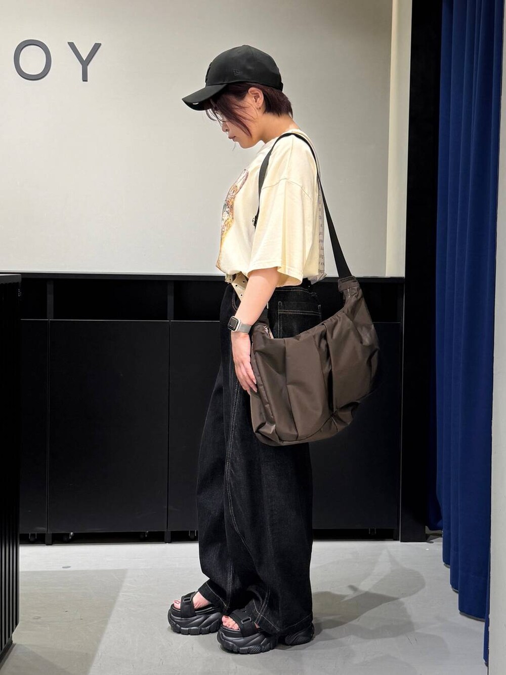 ブラック系のサンダル、ベージュ系のTシャツ/カットソー、ブラック系のデニムパンツを着用したレディースの夏コーディネートの4枚目の写真