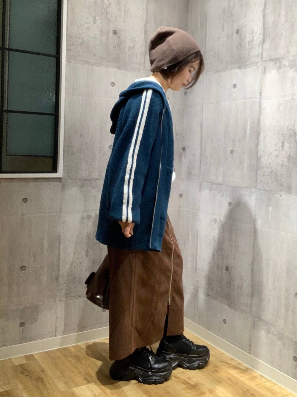 ブラック系のブーツ、ブラウン系のショルダーバッグ、ホワイト系のTシャツ/カットソーを着用したレディースの秋コーディネートの4枚目の写真