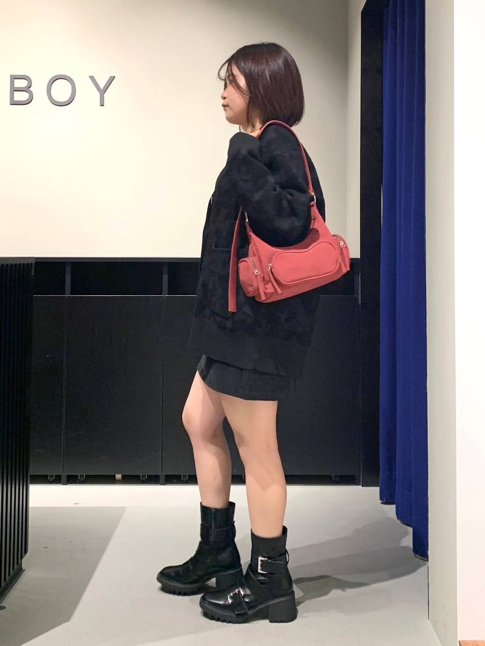 シルバー系のTシャツ/カットソー、ブラック系のスカート、ブラック系のブーツを着用したレディースの秋コーディネートの6枚目の写真