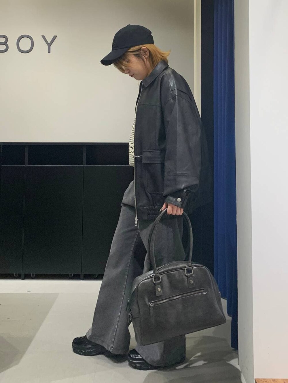 ブラック系のボストンバッグ、ブラック系のブルゾン、ブラック系のローファーを着用したレディースの冬コーディネートの6枚目の写真