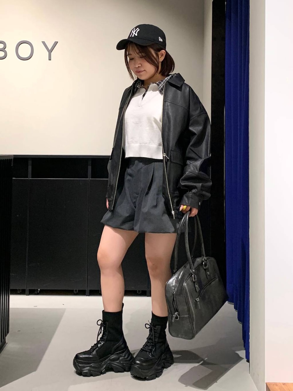 ブラック系のブーツ、ブラック系のボストンバッグ、ブラック系のブルゾンを着用したレディースの冬コーディネートの7枚目の写真