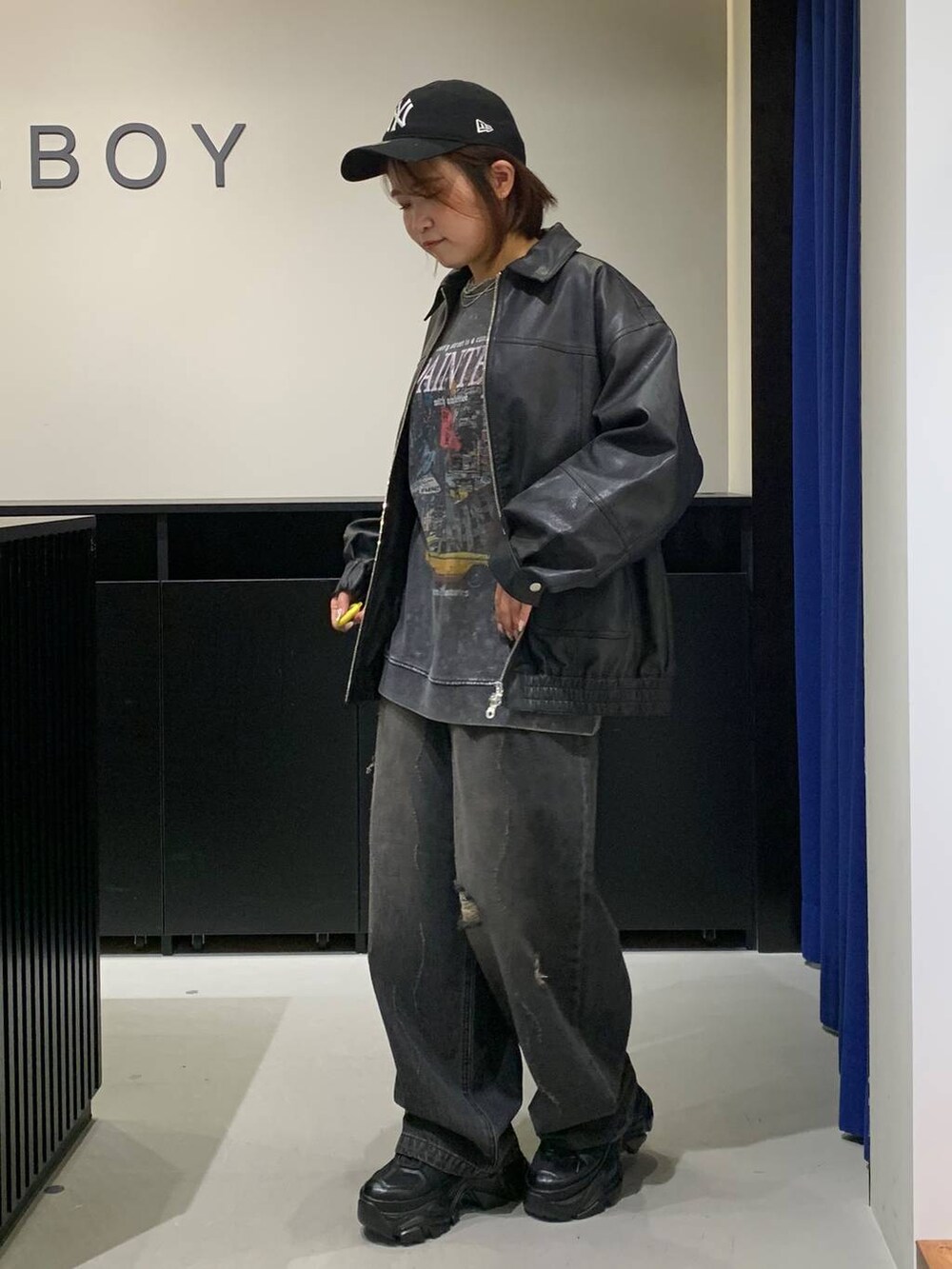 ブラック系のスニーカー、ブラック系のデニムパンツ、ブラック系のブルゾンを着用したレディースの秋コーディネートの6枚目の写真