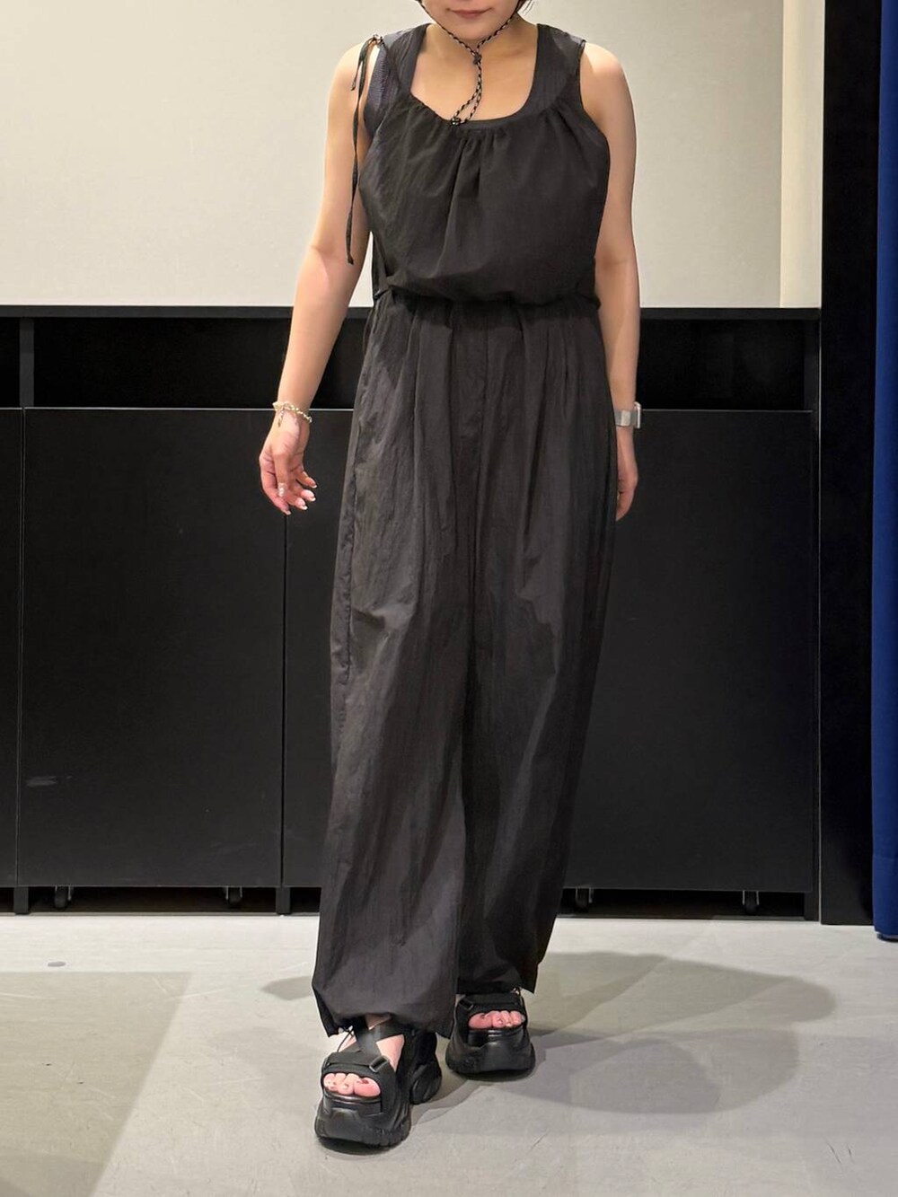ブラック系のサンダル、グレー系のタンクトップ、ブルー系のサロペット/オーバーオールを着用したレディースの夏コーディネートの2枚目の写真