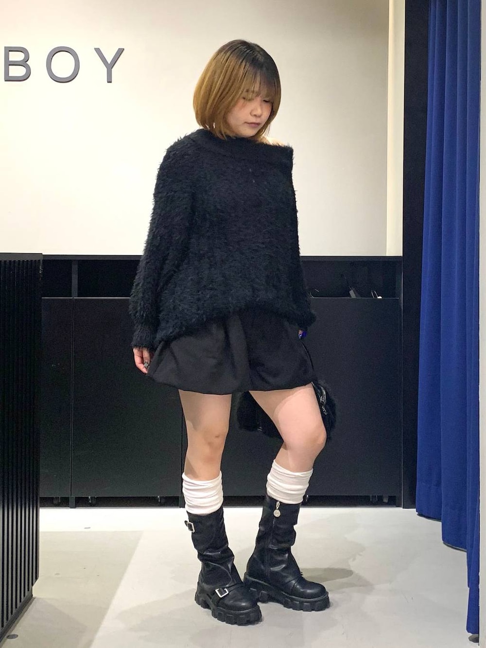 ホワイト系のキャミソール、ブラック系のワンピース、ブラック系のボストンバッグを着用したレディースの冬コーディネートの3枚目の写真