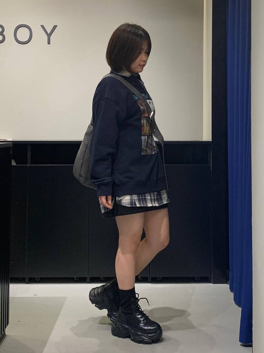 ブラック系のブーツ、グレー系のショルダーバッグ、ブラック系のスカートを着用したレディースの秋コーディネートの3枚目の写真