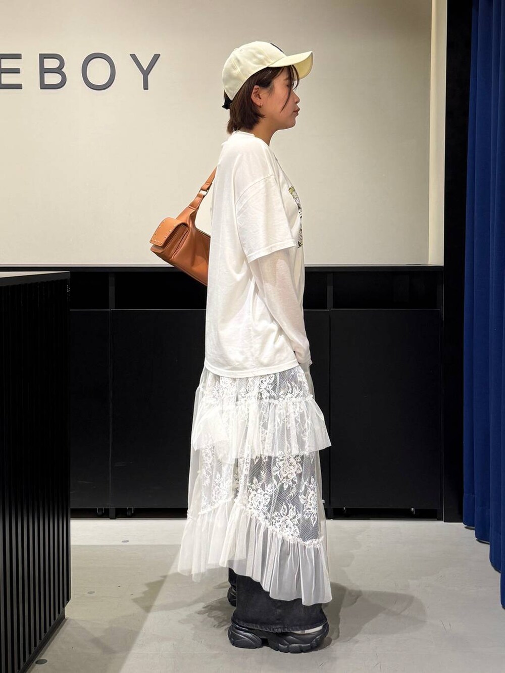 グレー系のサンダル、ブラック系のデニムパンツ、ブラウン系のショルダーバッグを着用したレディースの夏コーディネートの4枚目の写真