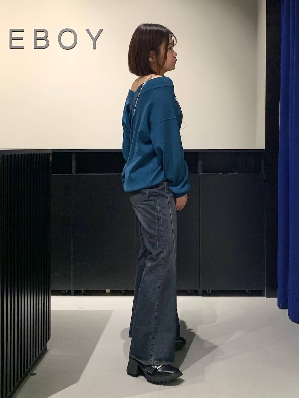 ホワイト系のキャミソール、ブルー系のデニムパンツ、グリーン系のニット/セーターを着用したレディースの秋コーディネートの4枚目の写真