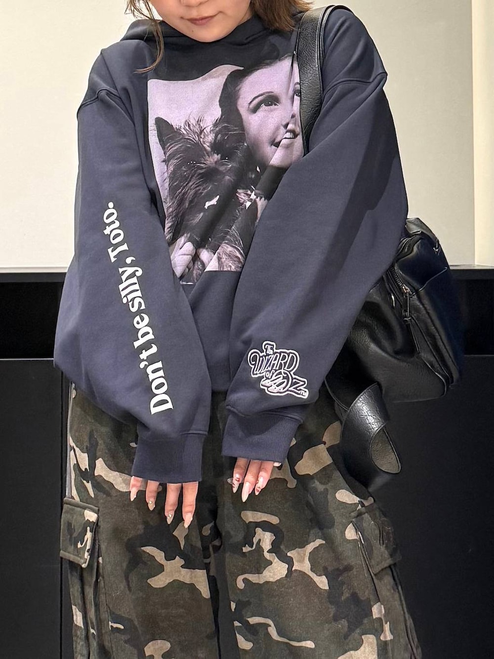 ブラック系のスニーカー、ブラック系のボストンバッグ、グリーン系のスウェットパンツを着用したレディースの冬コーディネートの3枚目の写真