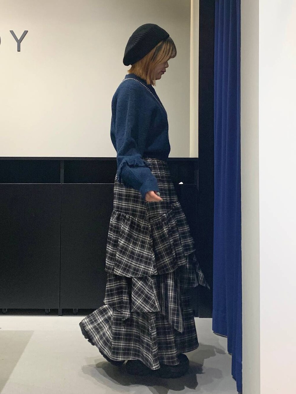 ブラック系のブーツ、ブラック系のスカート、ブラック系のハンドバッグを着用したレディースの冬コーディネートの4枚目の写真