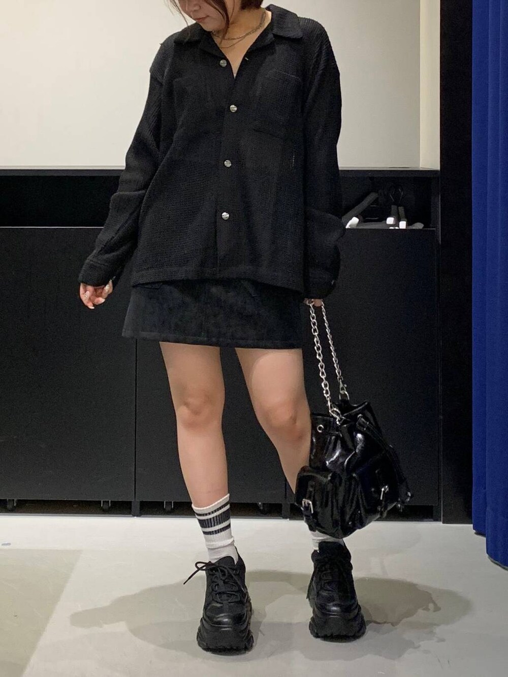 ブラック系のスニーカー、ブラック系のシャツ/ブラウス、ブラック系のショルダーバッグを着用したレディースの秋コーディネートの2枚目の写真