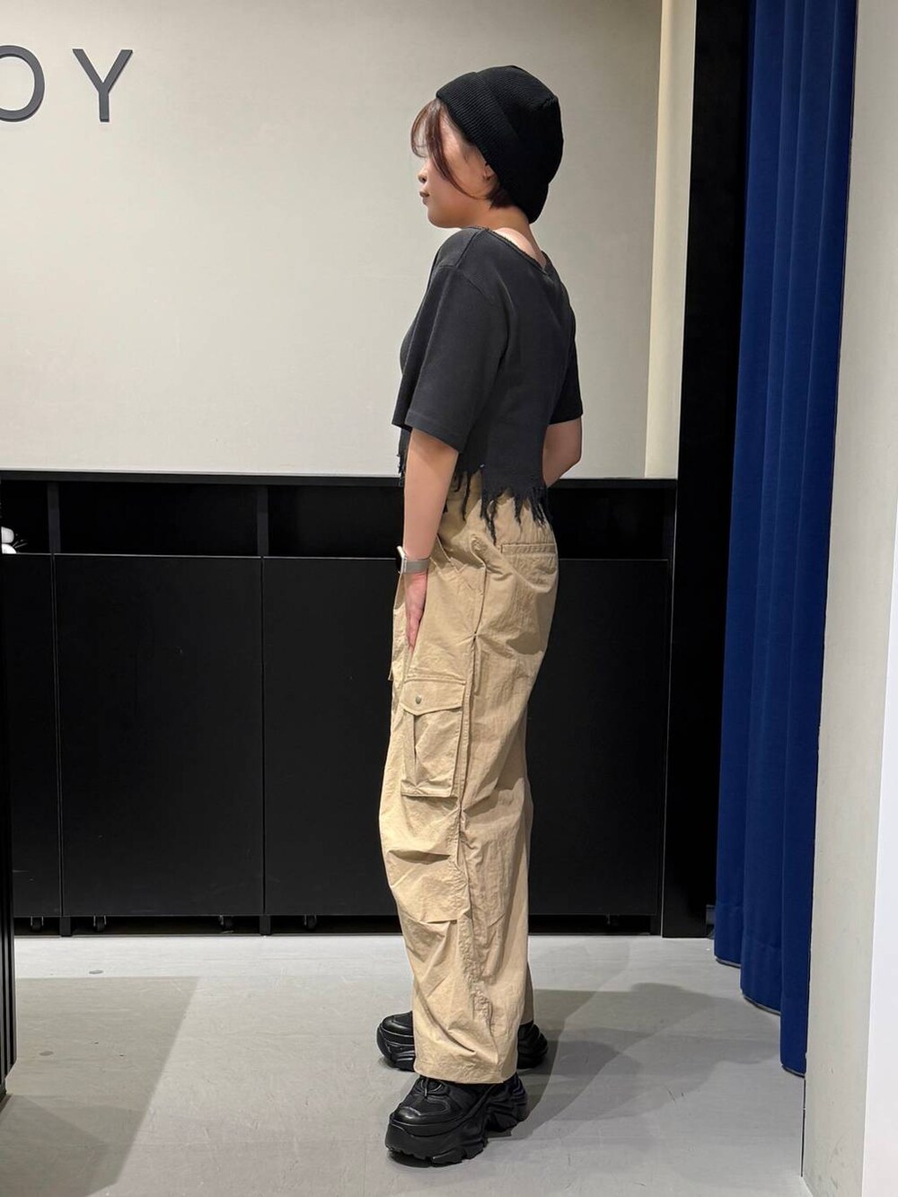 ブラック系のスニーカー、ブラック系のTシャツ/カットソー、ベージュ系のカーゴパンツを着用したレディースの夏コーディネートの5枚目の写真