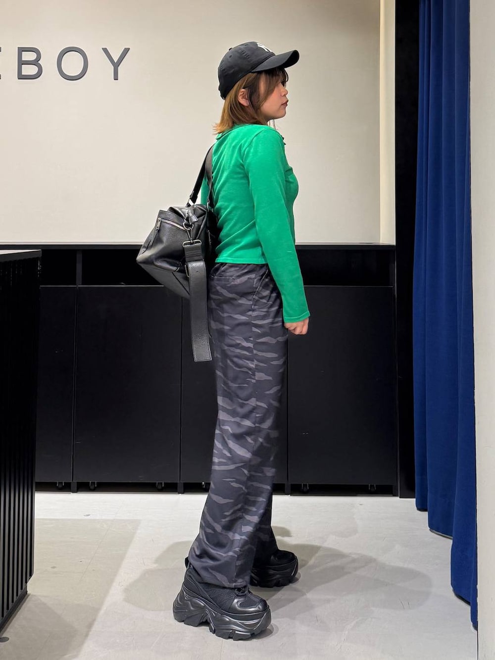 ブラック系のスニーカー、ホワイト系のキャミソール、ブラック系のボストンバッグを着用したレディースの冬コーディネートの4枚目の写真