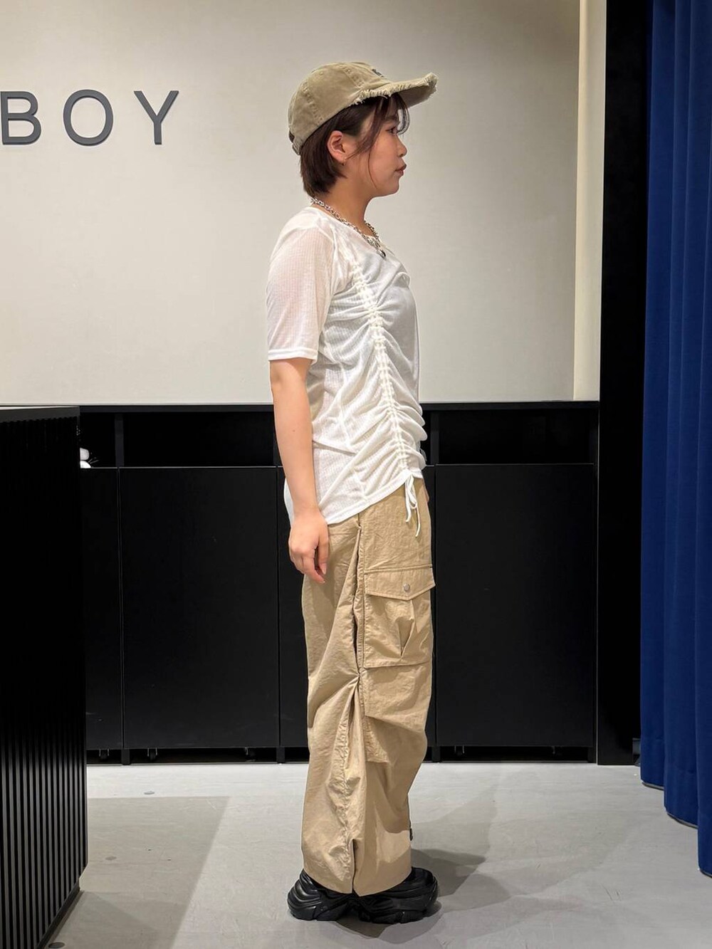 ブラック系のスニーカー、ベージュ系のカーゴパンツ、ホワイト系のTシャツ/カットソーを着用したレディースの夏コーディネートの3枚目の写真