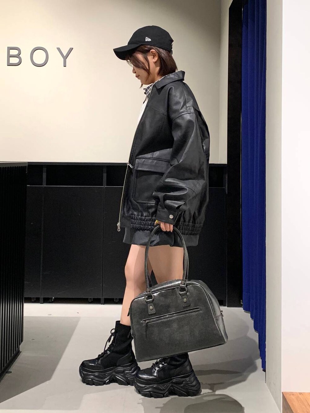 ブラック系のブーツ、ブラック系のボストンバッグ、ブラック系のブルゾンを着用したレディースの冬コーディネートの6枚目の写真