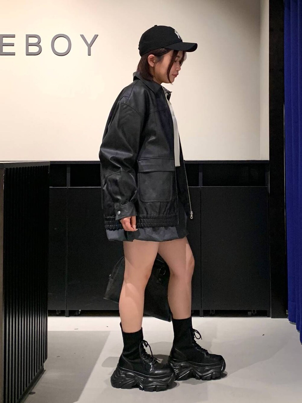 ブラック系のブーツ、ブラック系のボストンバッグ、ブラック系のブルゾンを着用したレディースの冬コーディネートの4枚目の写真