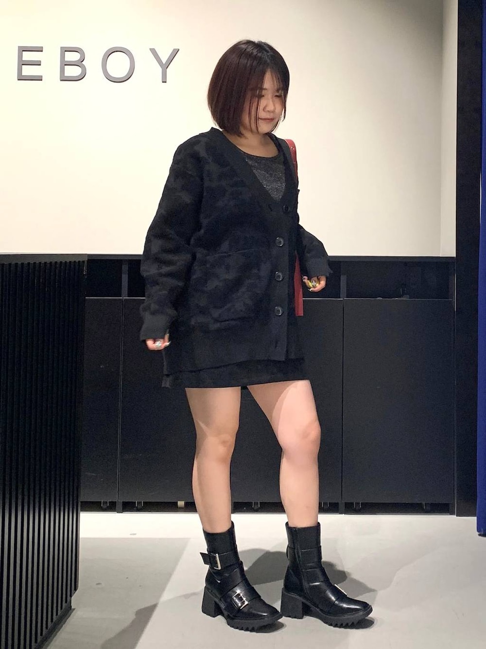 シルバー系のTシャツ/カットソー、ブラック系のスカート、ブラック系のブーツを着用したレディースの秋コーディネートの3枚目の写真