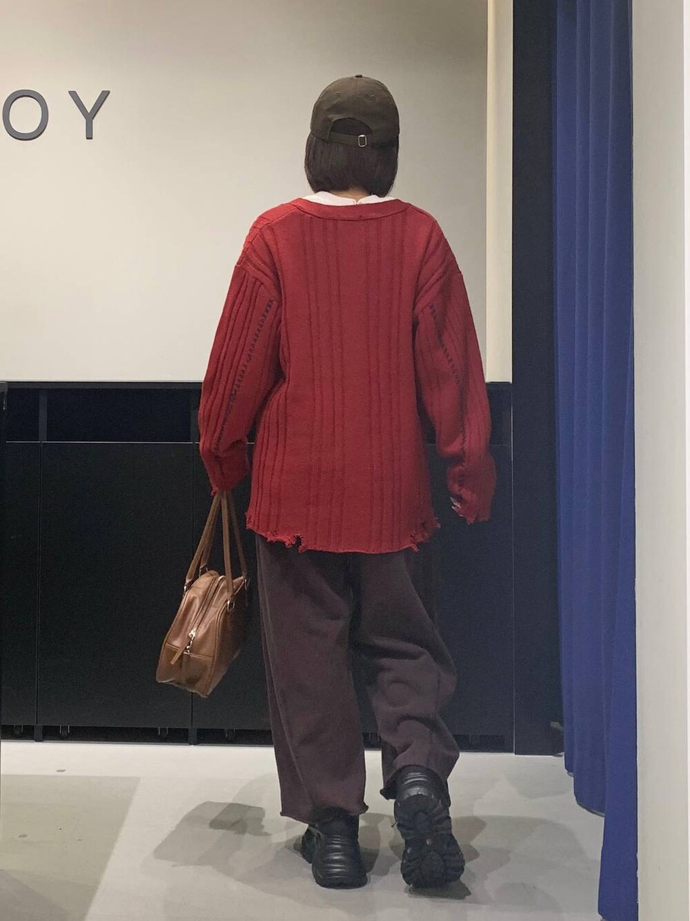 ブラック系のブーツ、ブラウン系のスウェットパンツ、イエロー系のボストンバッグを着用したレディースの秋コーディネートの5枚目の写真