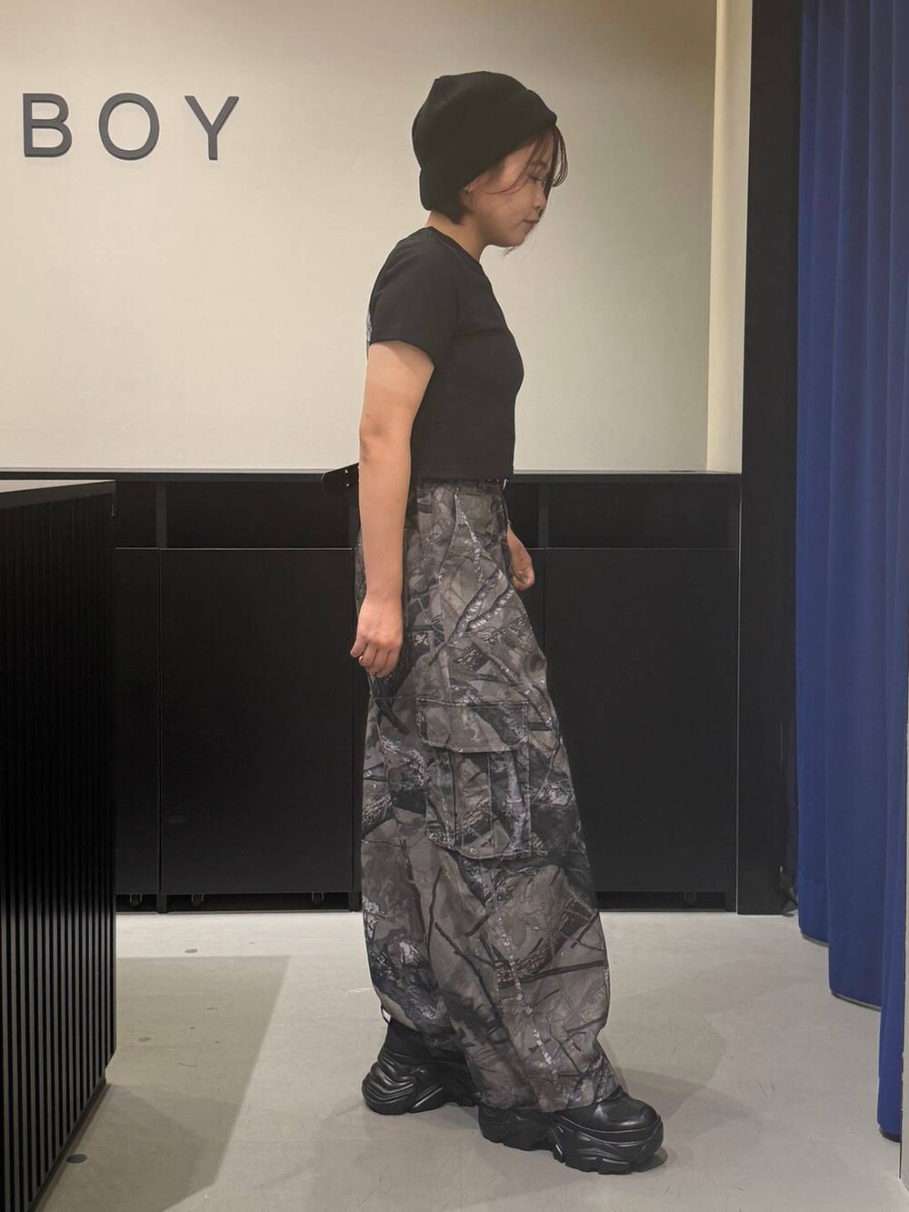 ブラック系のスニーカー、グレー系のカーゴパンツ、ブラック系のTシャツ/カットソーを着用したレディースの夏コーディネートの4枚目の写真