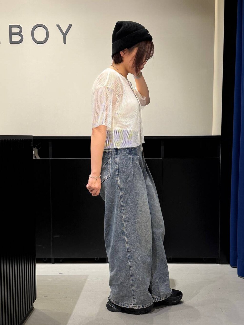 ブルー系のデニムパンツ、ブラック系のスニーカー、ホワイト系のTシャツ/カットソーを着用したレディースの夏コーディネートの3枚目の写真