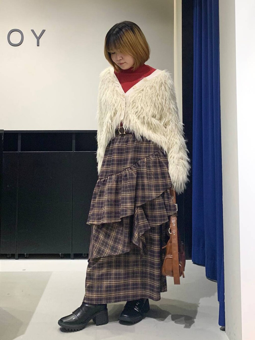 ブラック系のブーツ、ブラウン系のスカート、ブラウン系のショルダーバッグを着用したレディースの冬コーディネートの7枚目の写真