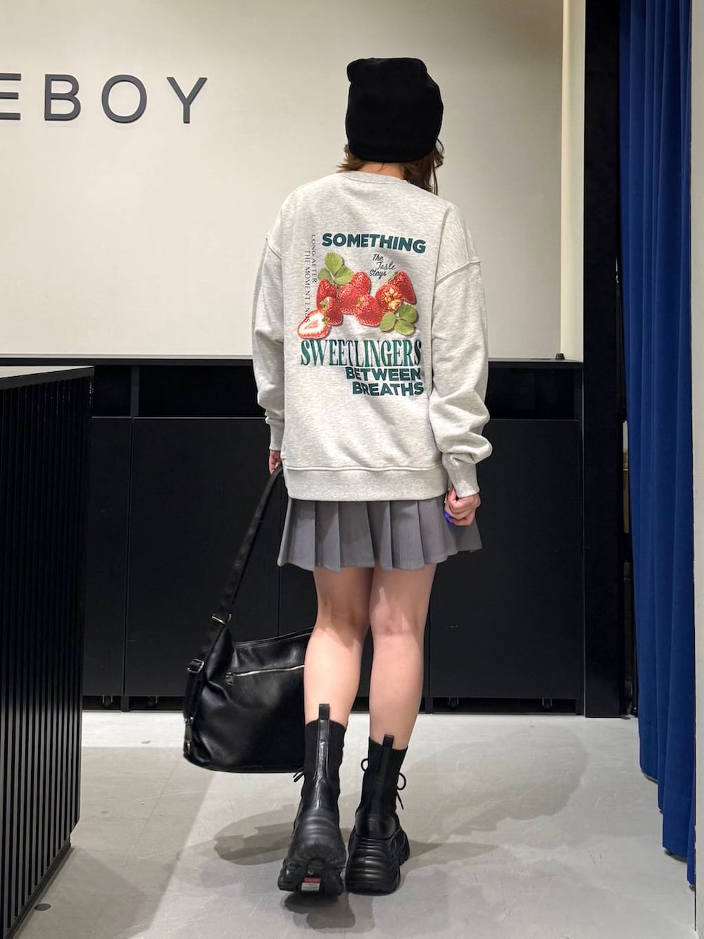 ブラック系のブーツ、グレー系のスウェット、ブラック系のショルダーバッグを着用したレディースの冬コーディネートの5枚目の写真