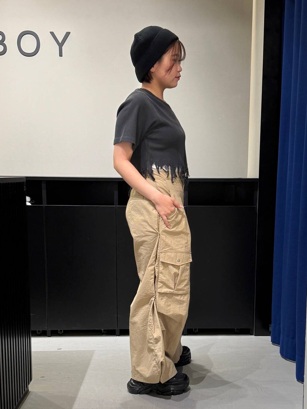 ブラック系のスニーカー、ブラック系のTシャツ/カットソー、ベージュ系のカーゴパンツを着用したレディースの夏コーディネートの3枚目の写真