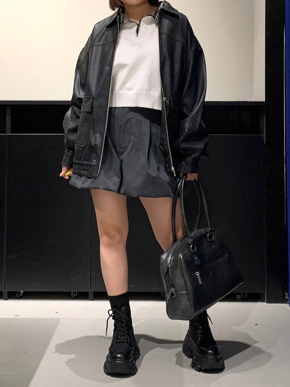 ブラック系のブーツ、ブラック系のボストンバッグ、ブラック系のブルゾンを着用したレディースの冬コーディネートの2枚目の写真