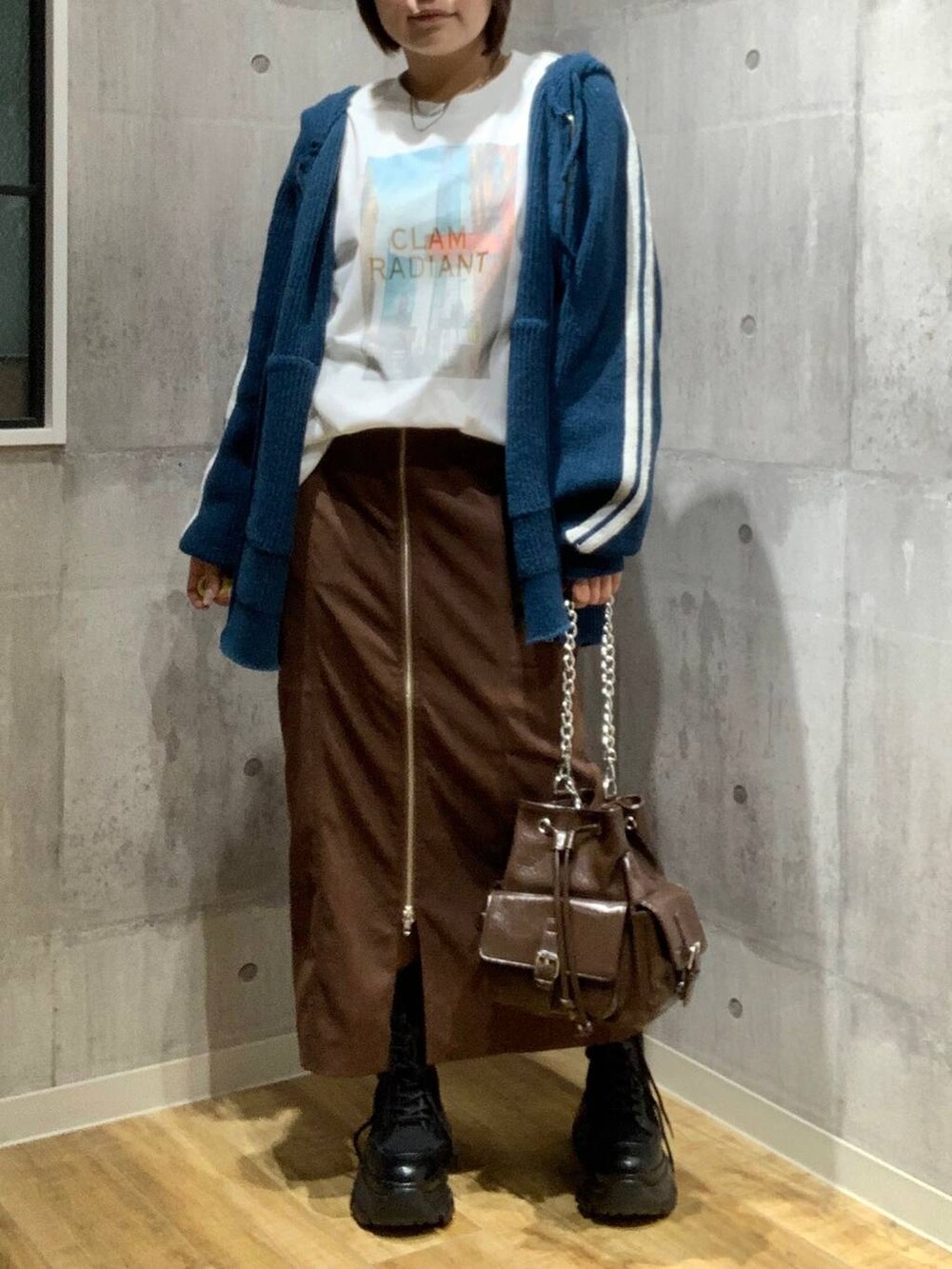 ブラック系のブーツ、ブラウン系のショルダーバッグ、ホワイト系のTシャツ/カットソーを着用したレディースの秋コーディネートの2枚目の写真