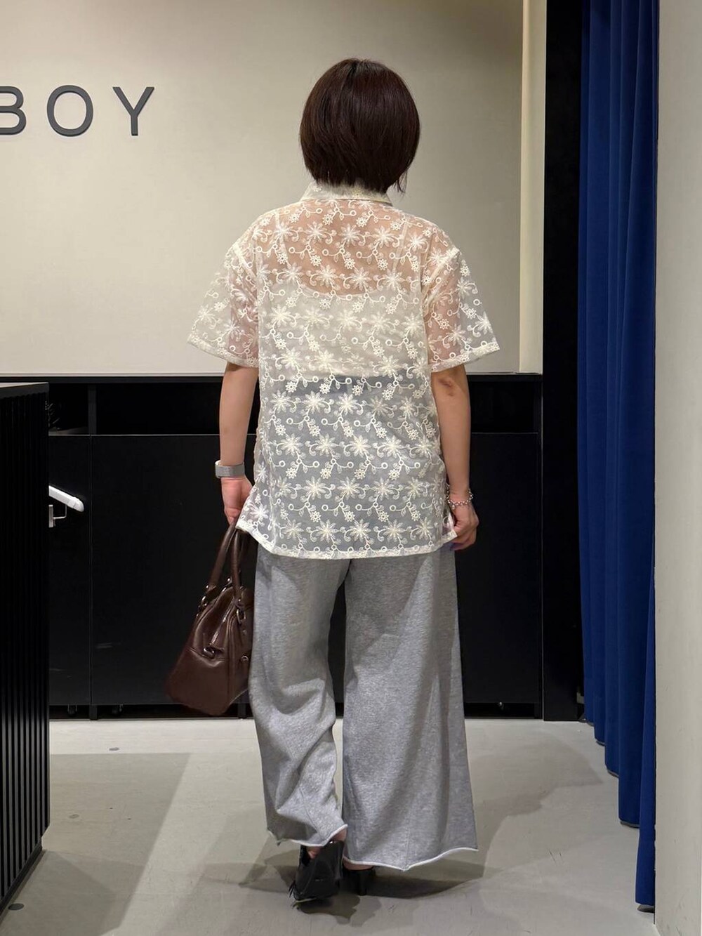 ホワイト系のキャミソール、ブラック系のサンダル、ブラウン系のショルダーバッグを着用したレディースの夏コーディネートの4枚目の写真