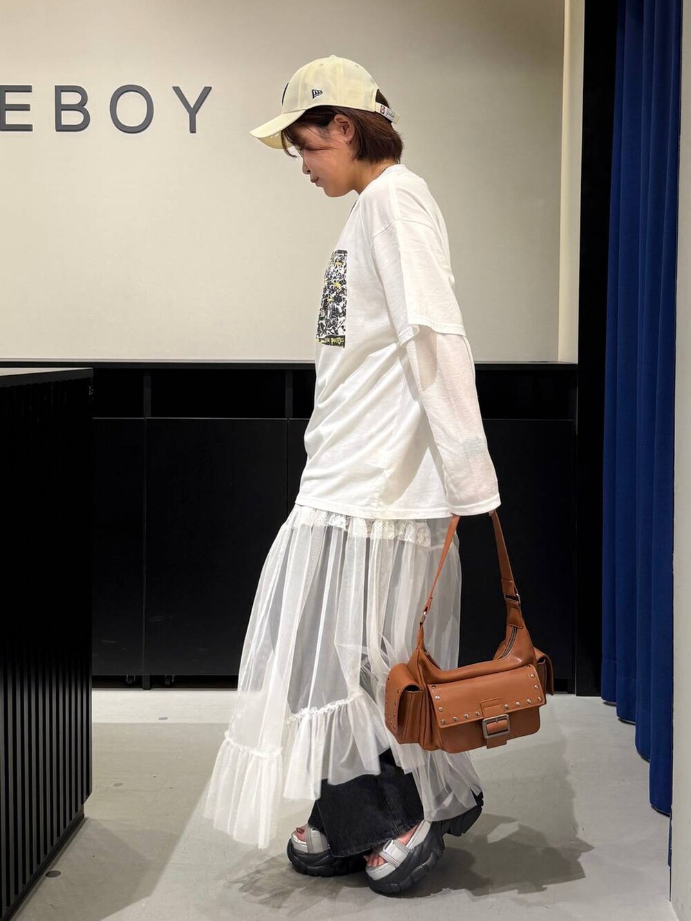 グレー系のサンダル、ブラック系のデニムパンツ、ブラウン系のショルダーバッグを着用したレディースの夏コーディネートの6枚目の写真