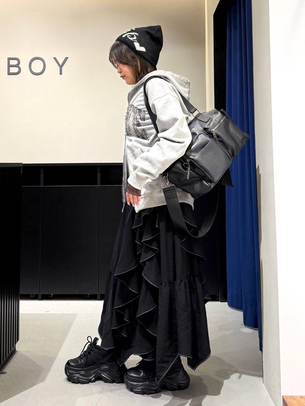 ブラック系のスニーカー、ブラック系のボストンバッグ、ブラック系のスカートを着用したレディースの冬コーディネートの6枚目の写真