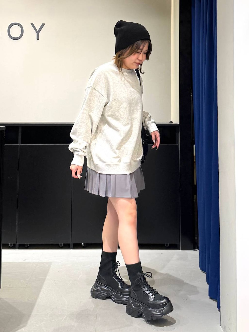 ブラック系のブーツ、グレー系のスウェット、ブラック系のショルダーバッグを着用したレディースの冬コーディネートの3枚目の写真