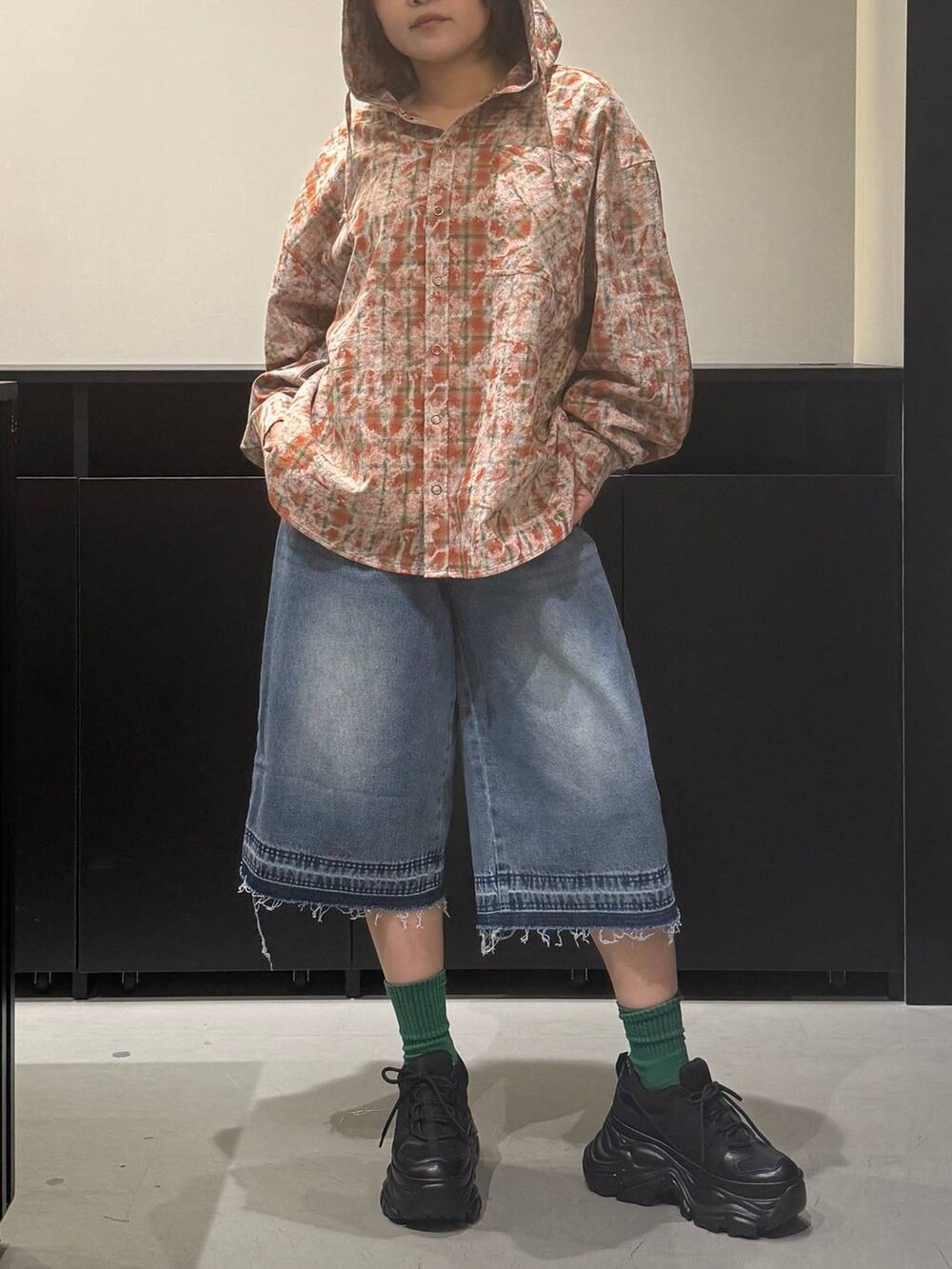 ブラック系のスニーカー、ブルー系のデニムパンツ、オレンジ系のシャツ/ブラウスを着用したレディースの夏コーディネートの2枚目の写真